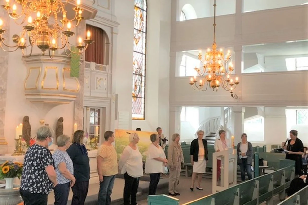Ehrenamtliche Lydia-Frauen stehen vor dem Altar in der St. Petri Kirche