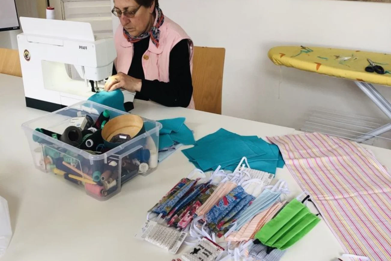 Frau mit Nähmaschine, näht Mundschutzmaske