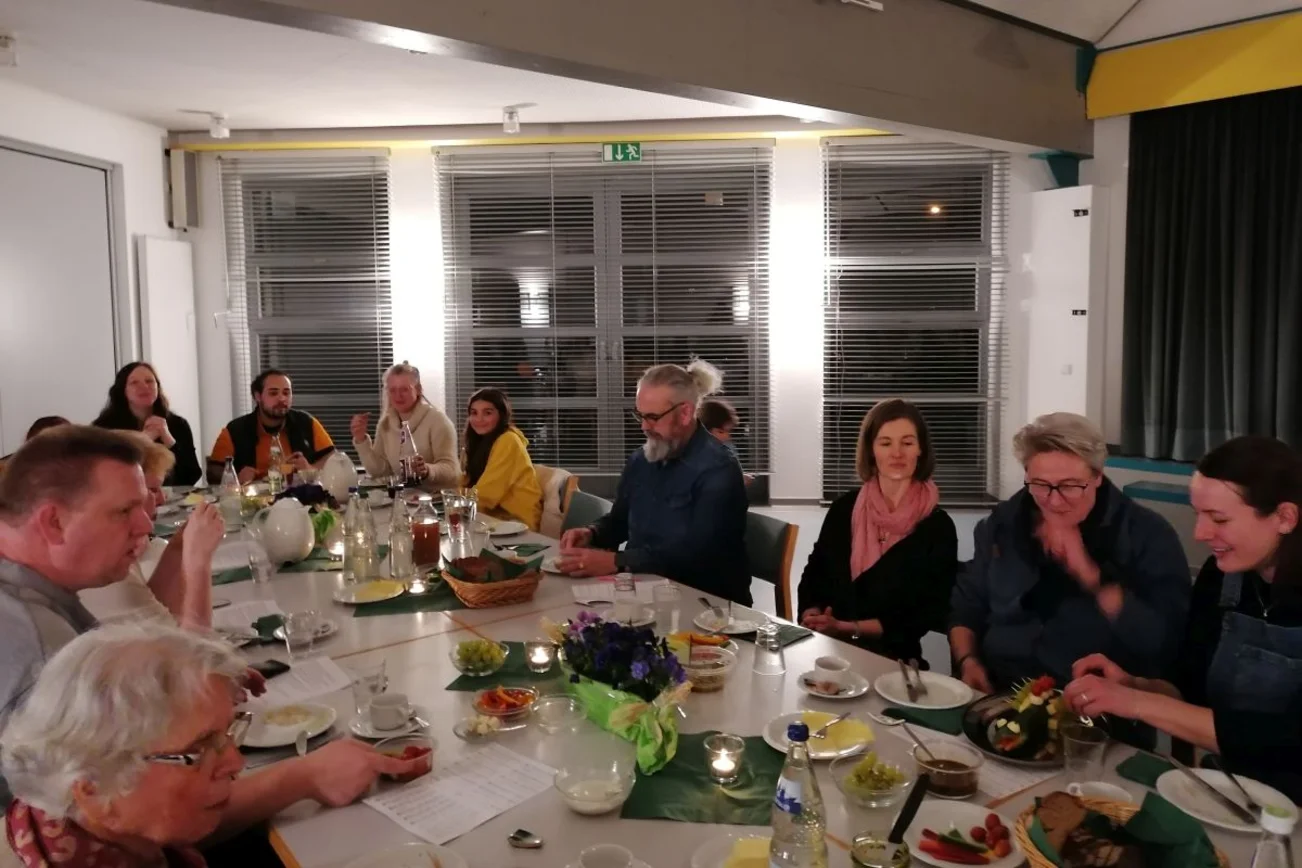 Menschen sitzen am gedeckten Tisch