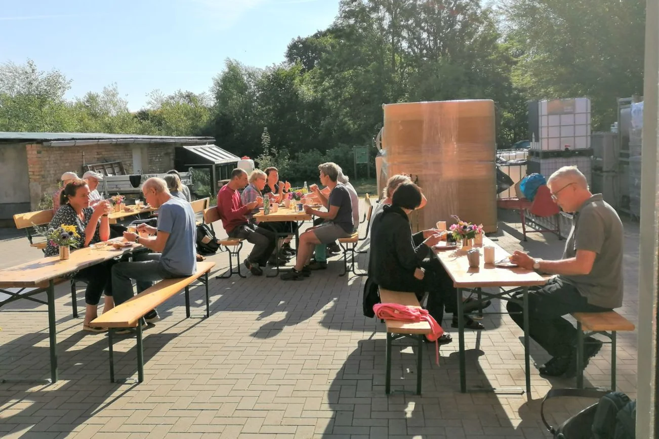 mehrere Personen sitzen an Tischen und essen