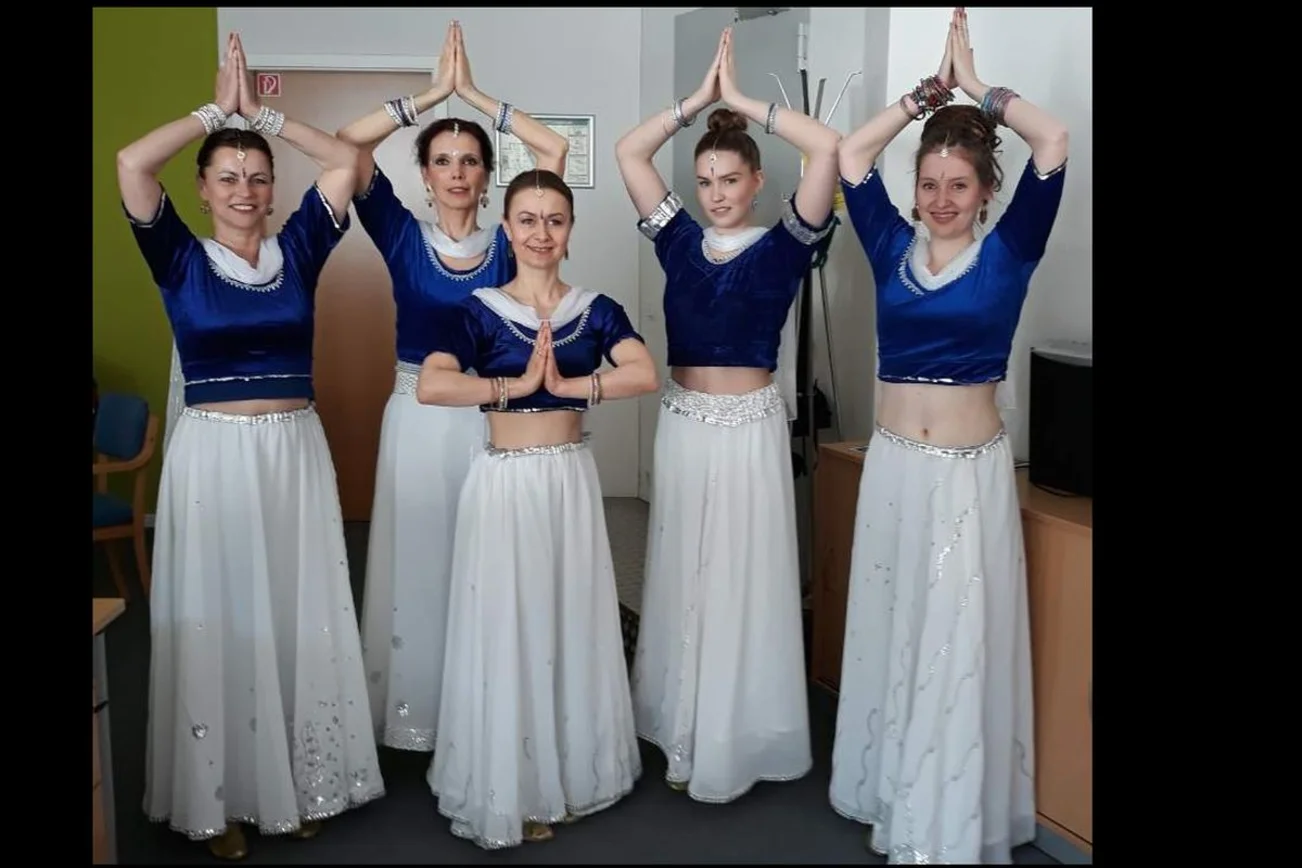 fünf Bollywoodtänzerinnen posieren in weißem Rock und blauem Shirt 