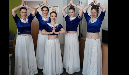 fünf Bollywoodtänzerinnen posieren in weißem Rock und blauem Shirt 