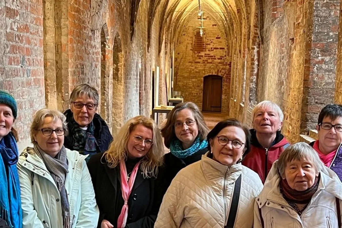 Frauen des Beirats stehen in einem Kreuzgang