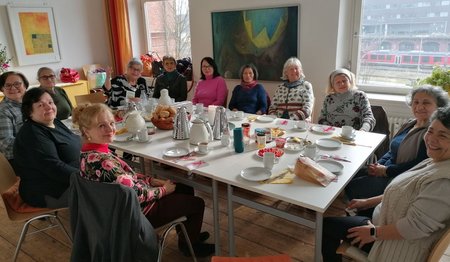 Frauen sitzen an einem reich gedeckten Tisch