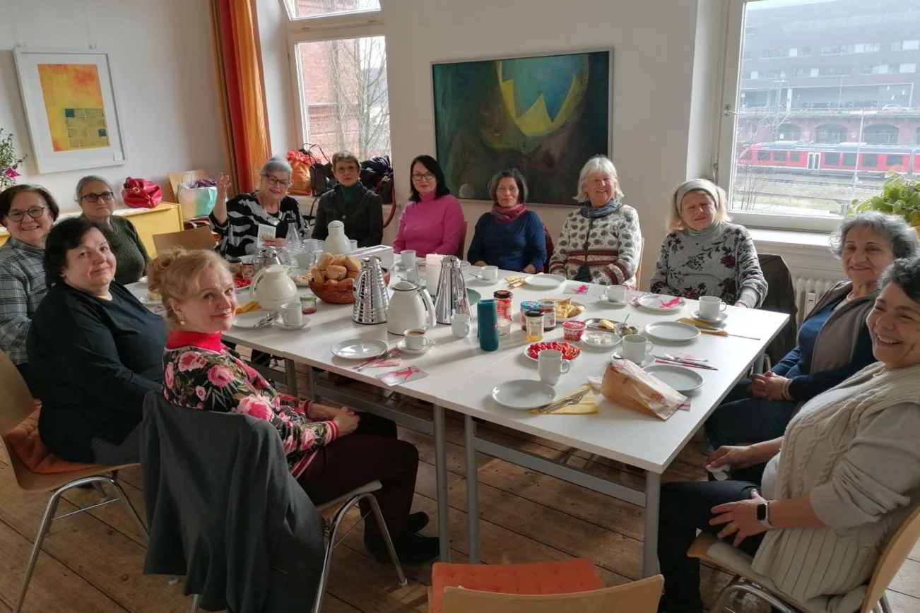 Frauen sitzen an einem reich gedeckten Tisch
