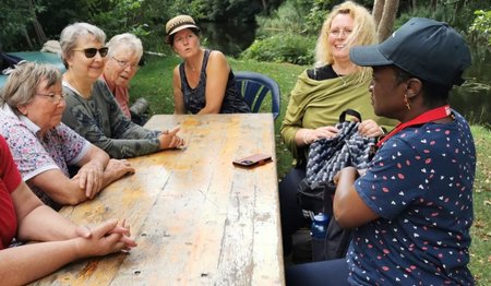 Frauen sitzen am Tisch im Grünen