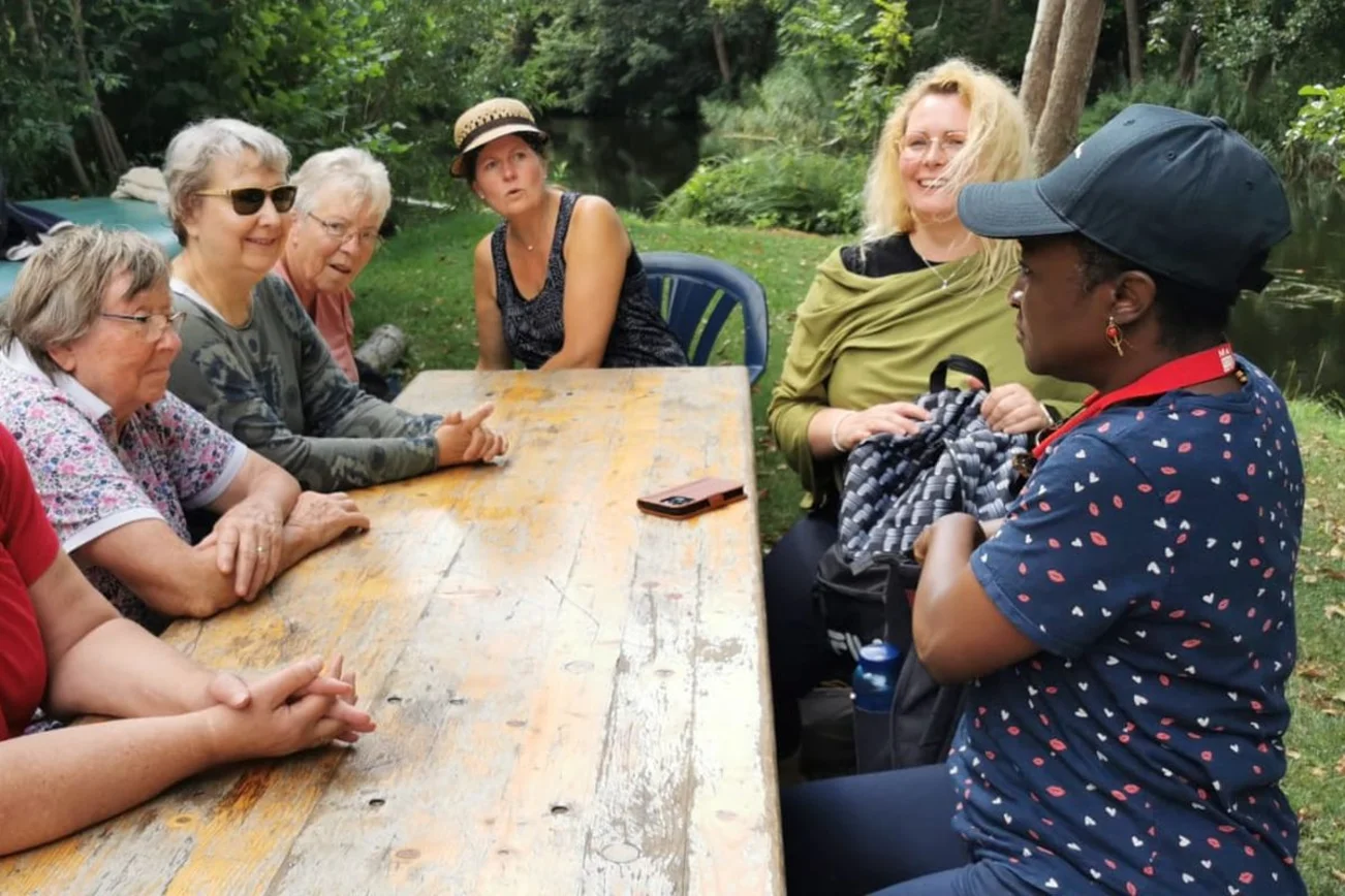 Frauen sitzen am Tisch im Grünen
