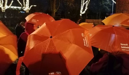 orange Schirme mit Aufschrift Gewalt behindert