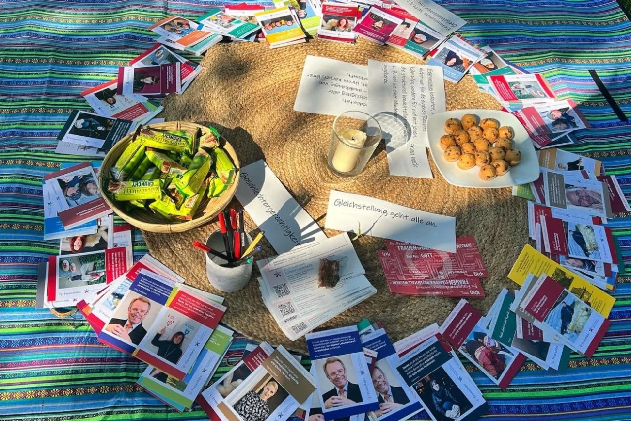 viele Karten mit Texte liegen auf einem Tuch auf der Wiese