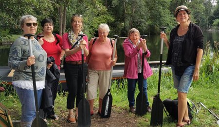 Sechs  Frauen stehen mit Paddel in der Hand