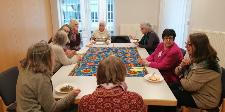 Frauen sitzen rund um einen Tisch