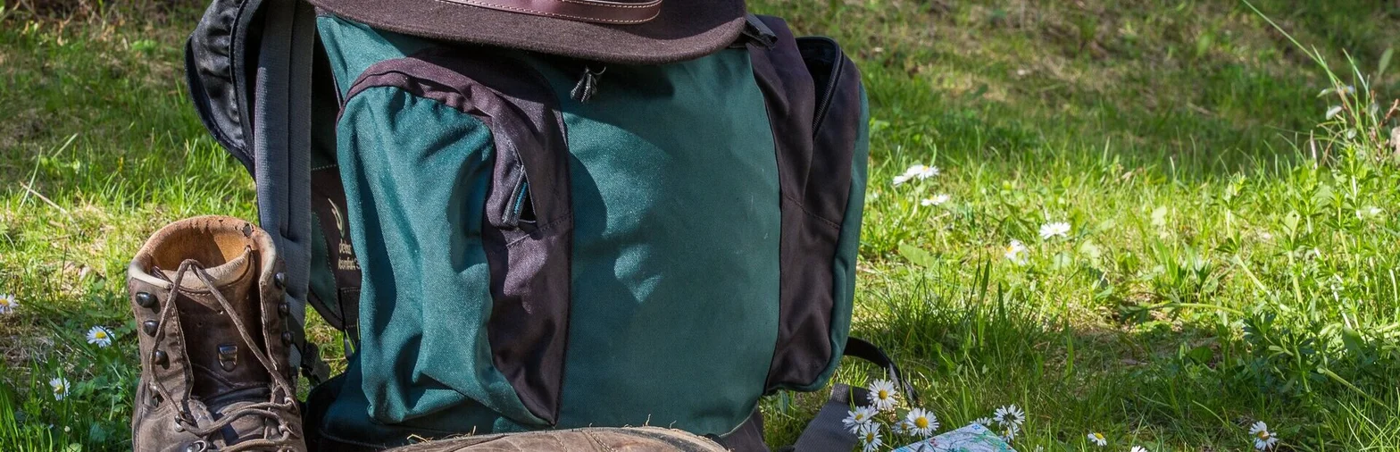 Wanderschuhe, Rucksack mit Hut und Karte
