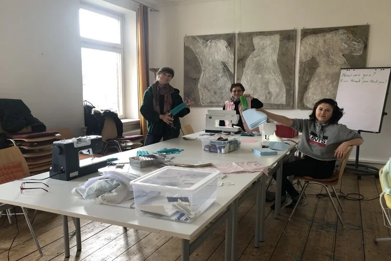drei Frauen am Tisch mit selbst genähten Mundschutzmasken