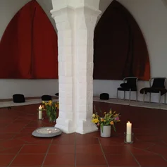 kirchenraum mit stühlen und kissen, kerzen und Blumen