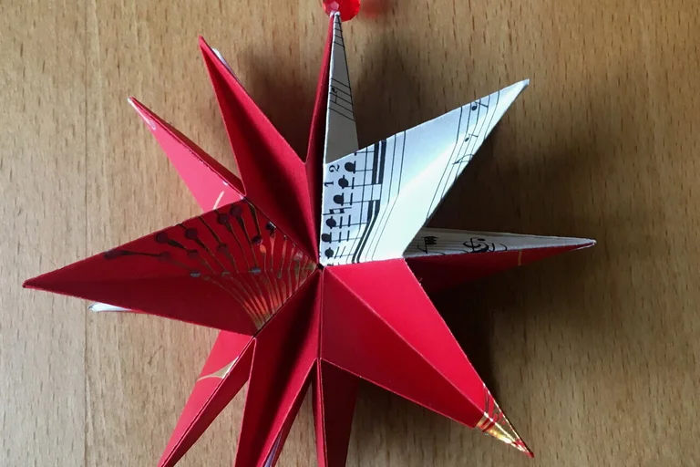 gefalteter Papierstern und Streichholzschachtel
