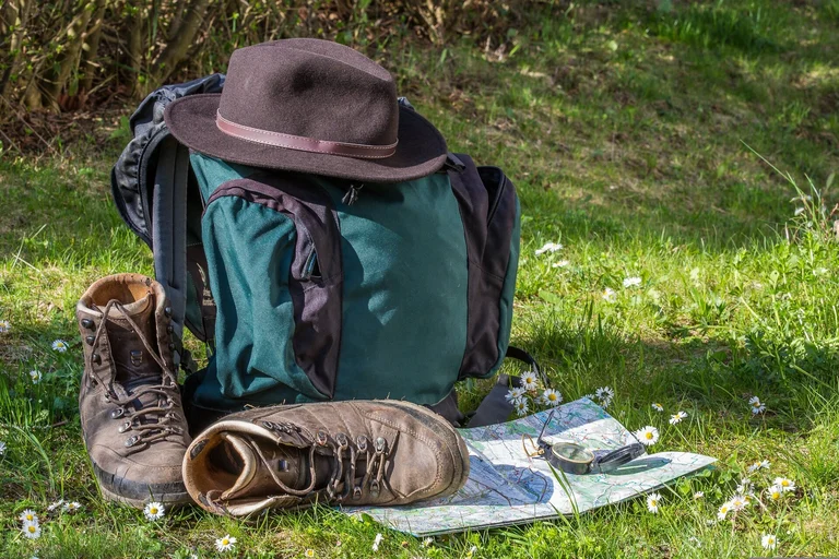 Wanderschuhe, Rucksack mit Hut und Karte